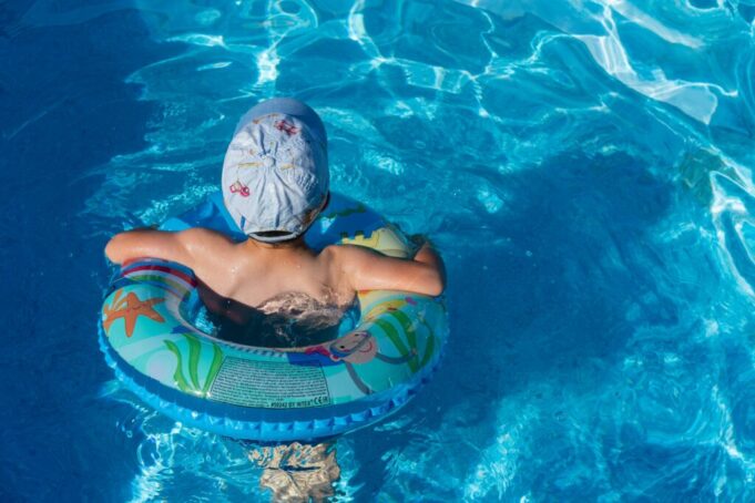 Child swimming with inflatables in the sun