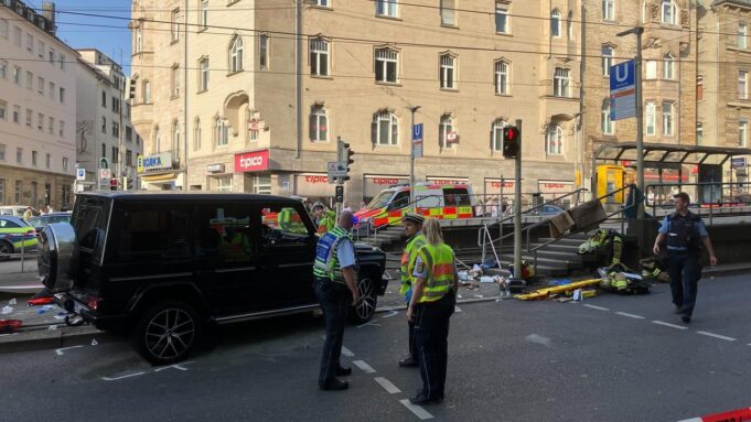 Mannfährt in Stuttgart MIT Auto aus Menschengruppe

